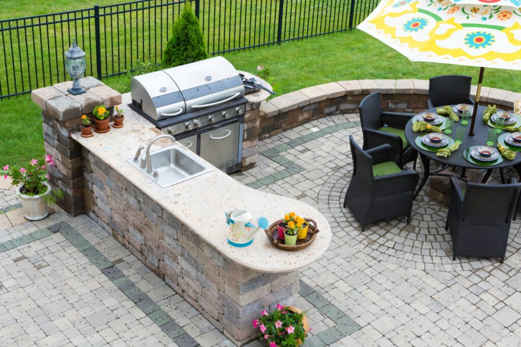 an outdoor kitchen with cooking area and seating area